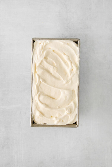 whipped cream in a metal box on a grey background.