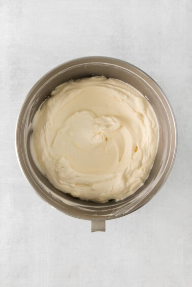 whipped cream in a bowl on a white surface.