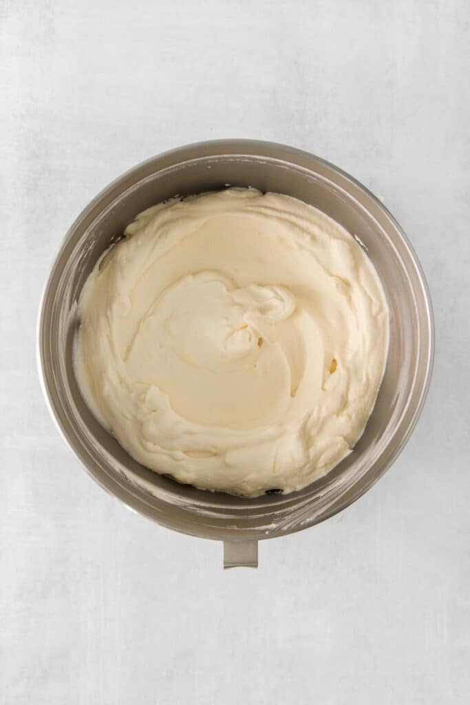 whipped cream in a bowl on a white surface.
