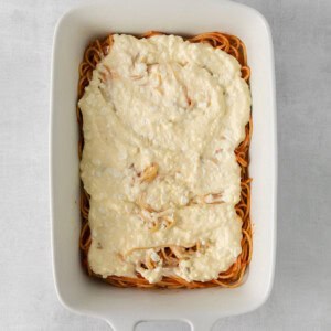 a white baking dish filled with pasta and cheese.