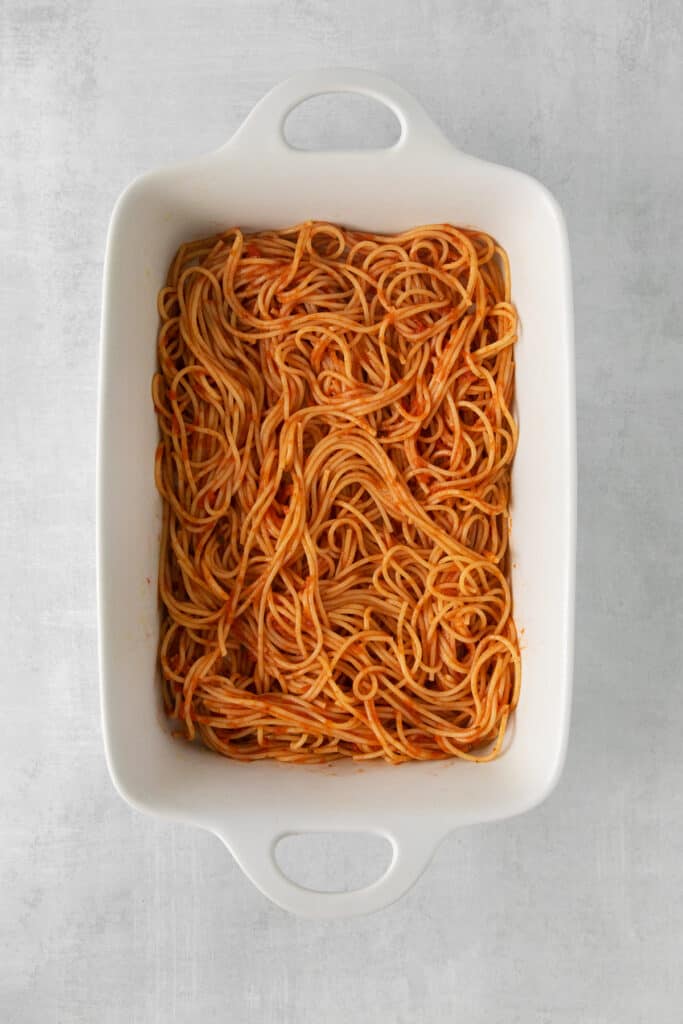 Spaghetti and red sauce in a casserole dish.