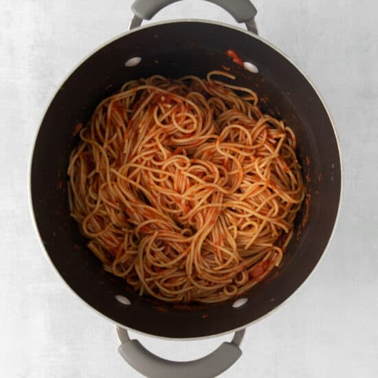 a pot filled with spaghetti on a white surface.