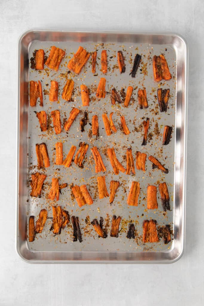 Parmesan smashed carrots on a baking sheet after being baked.