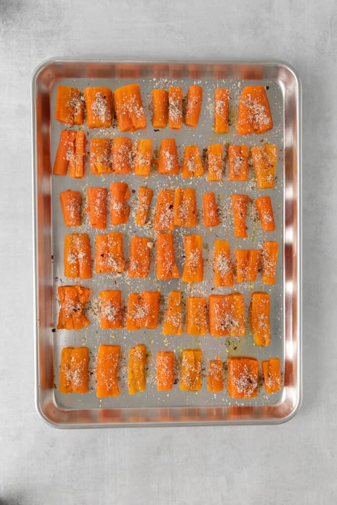 Parmesan smashed carrots on a baking sheet.