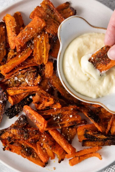 Parmesan smashed carrots on a plate with aioli dipping sauce.