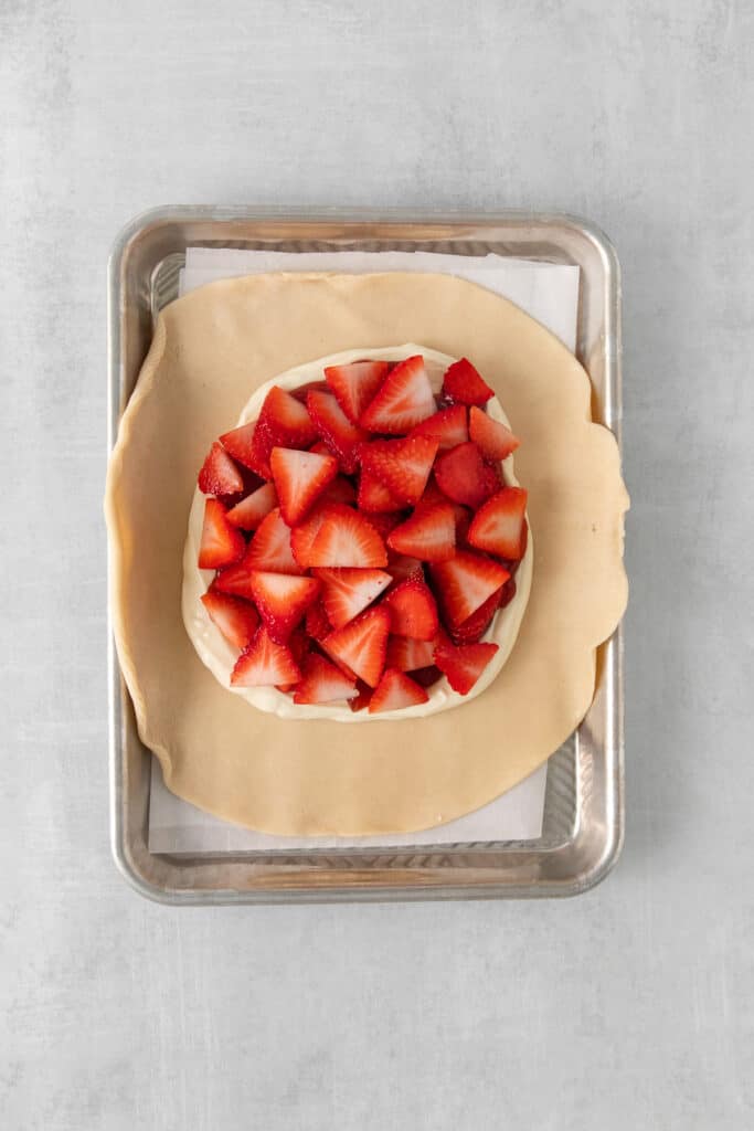 Strawberries atop cream cheese and a pie crust.