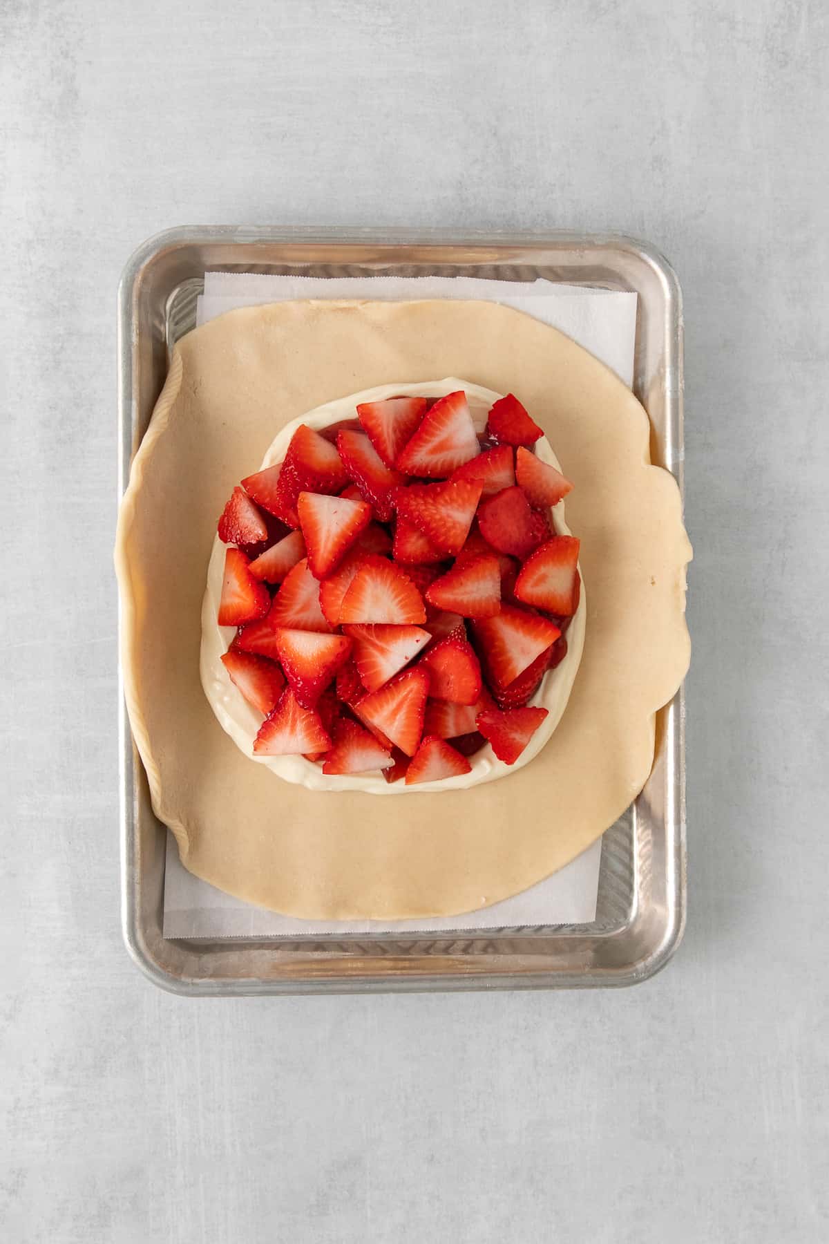 Strawberries atop cream cheese and a pie crust.