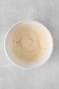 whipped cream in a white bowl on a gray background.