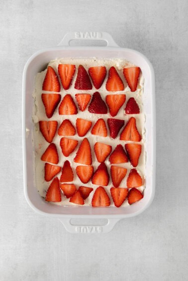 a white baking dish with strawberries in it.
