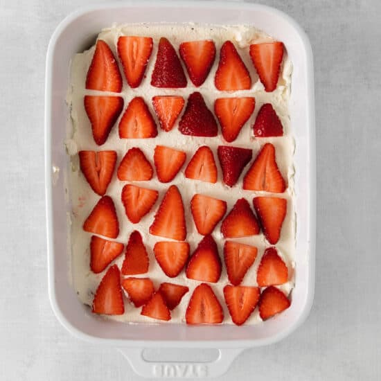 a white baking dish with strawberries in it.