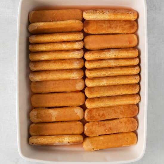a white dish filled with crackers on a grey background.