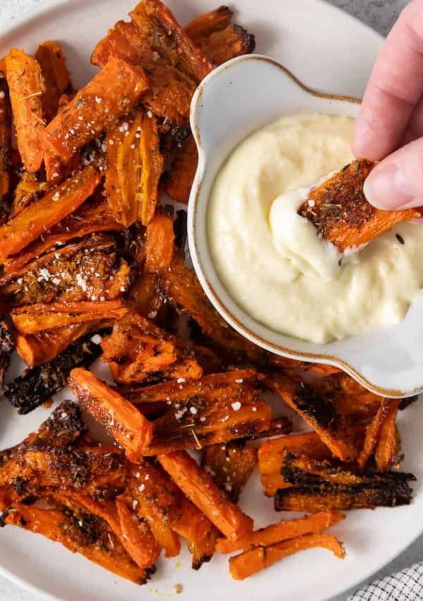 Parmesan smashed carrots on a plate with aioli dipping sauce.