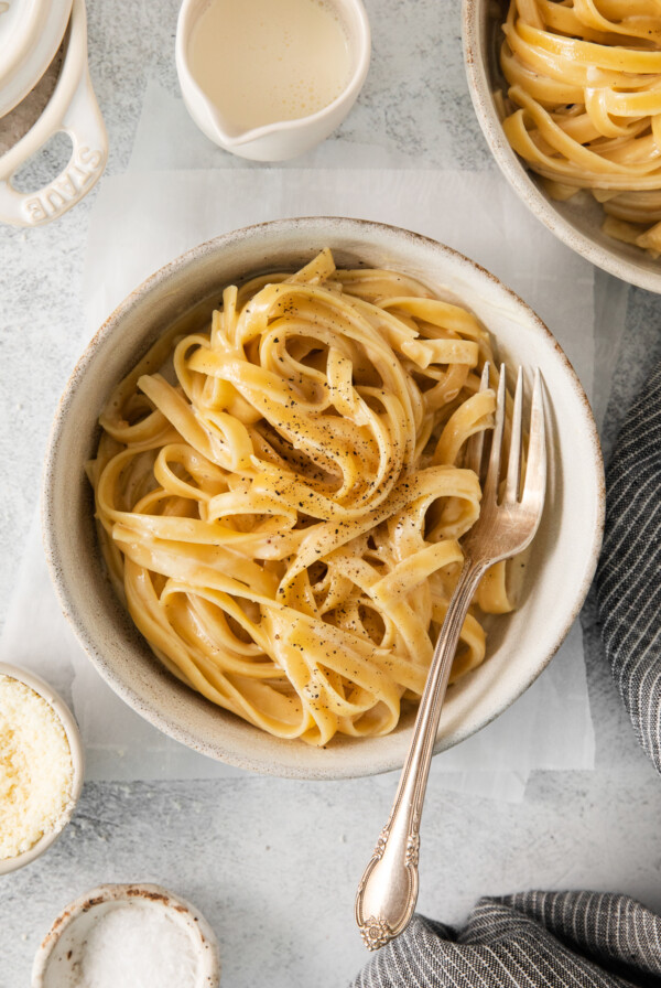 Homemade alfredo sauce over pasta in a bowl.