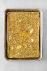 a square of omelette in a metal pan.