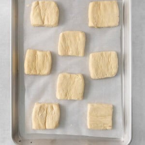 squares of dough on a baking sheet.