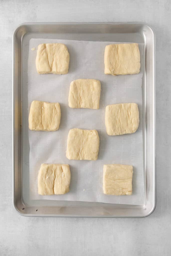 squares of dough on a baking sheet.