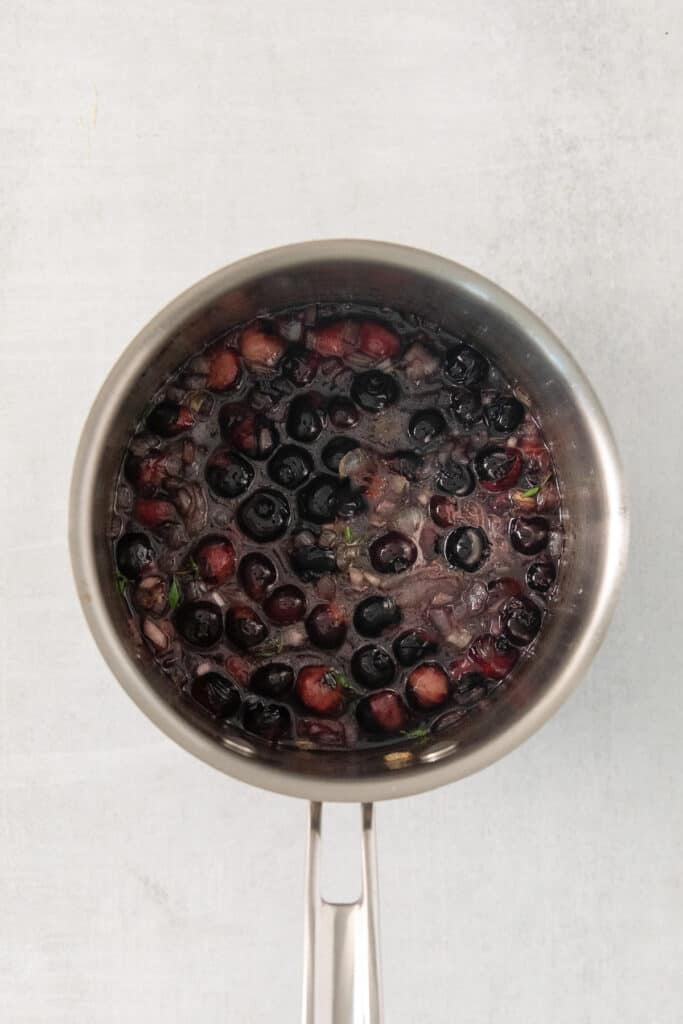 Blueberries cooking down in a stock pot.