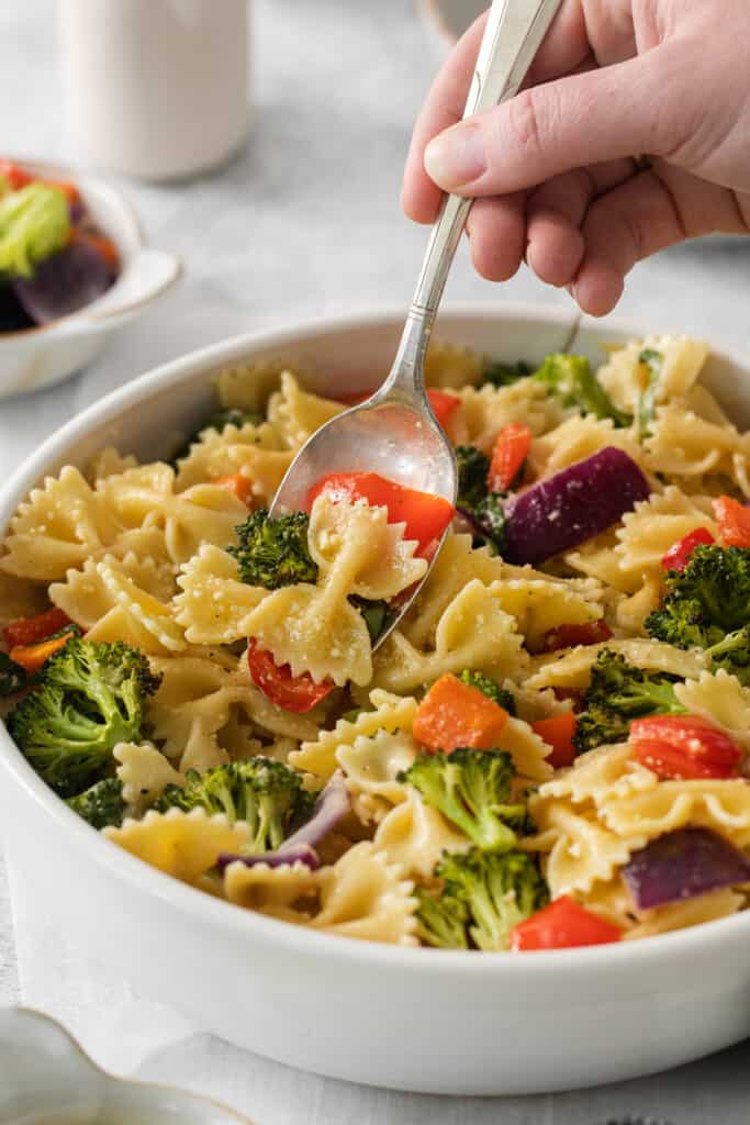 a bowl of pasta with broccoli and carrots.