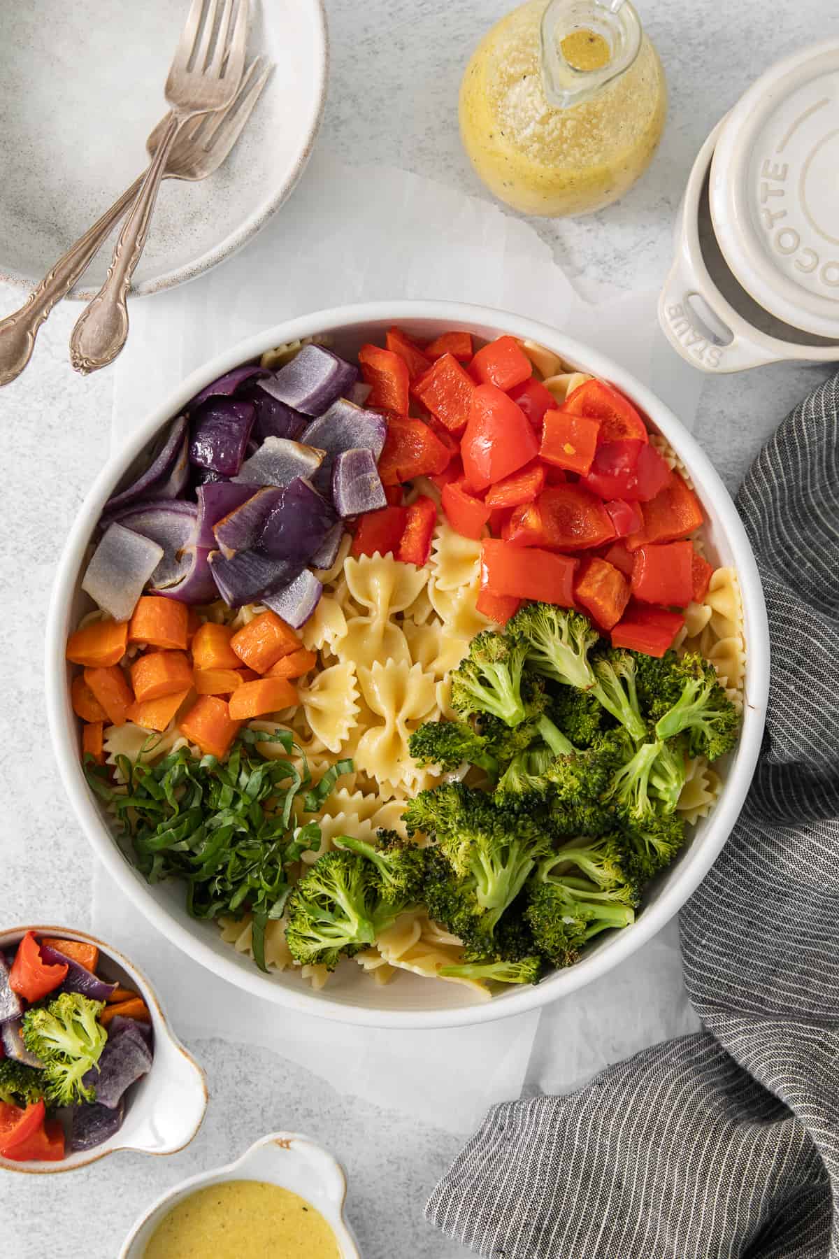 a white bowl filled with pasta and vegetables.