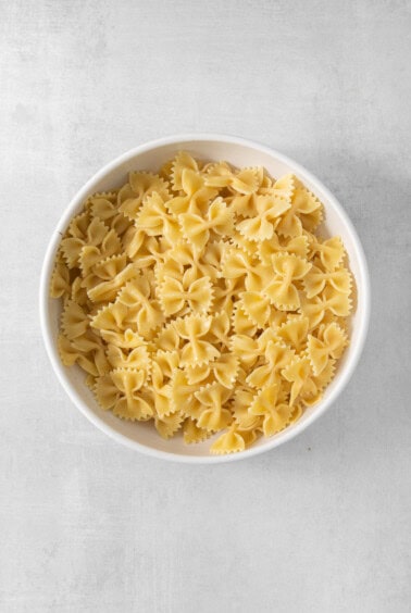 a white bowl filled with pasta on top of a table.