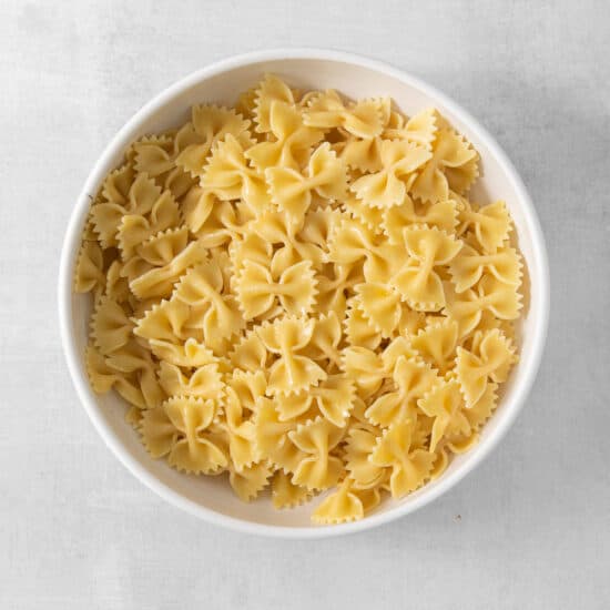 a white bowl filled with pasta on top of a table.
