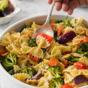 a bowl of pasta with broccoli and carrots.