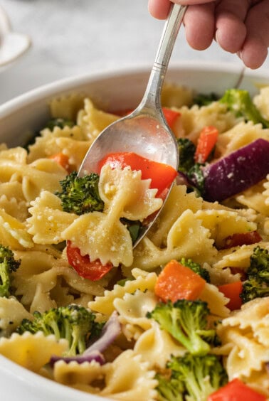 a bowl of pasta with broccoli and carrots.