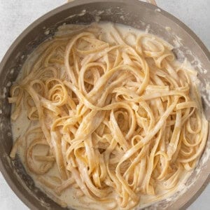 a pan with pasta in it on a white surface.