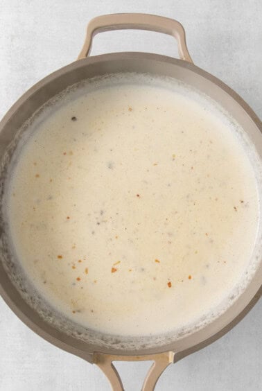 a pan full of soup on a white surface.