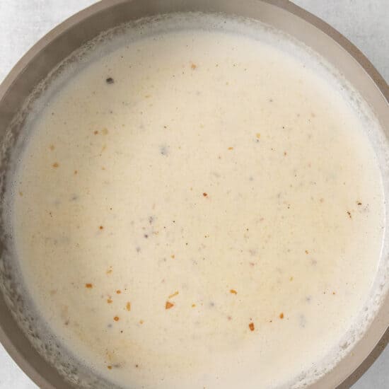 a pan full of soup on a white surface.