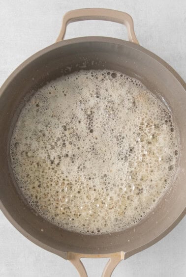 a pan filled with water and oil on a white surface.