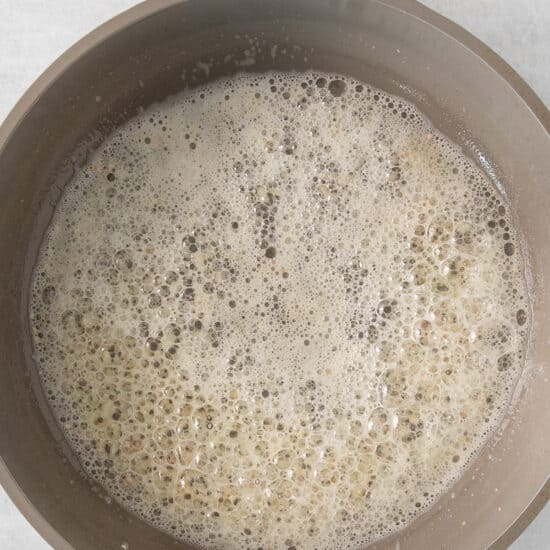 a pan filled with water and oil on a white surface.