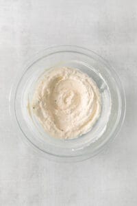 a bowl of hummus on a white background.