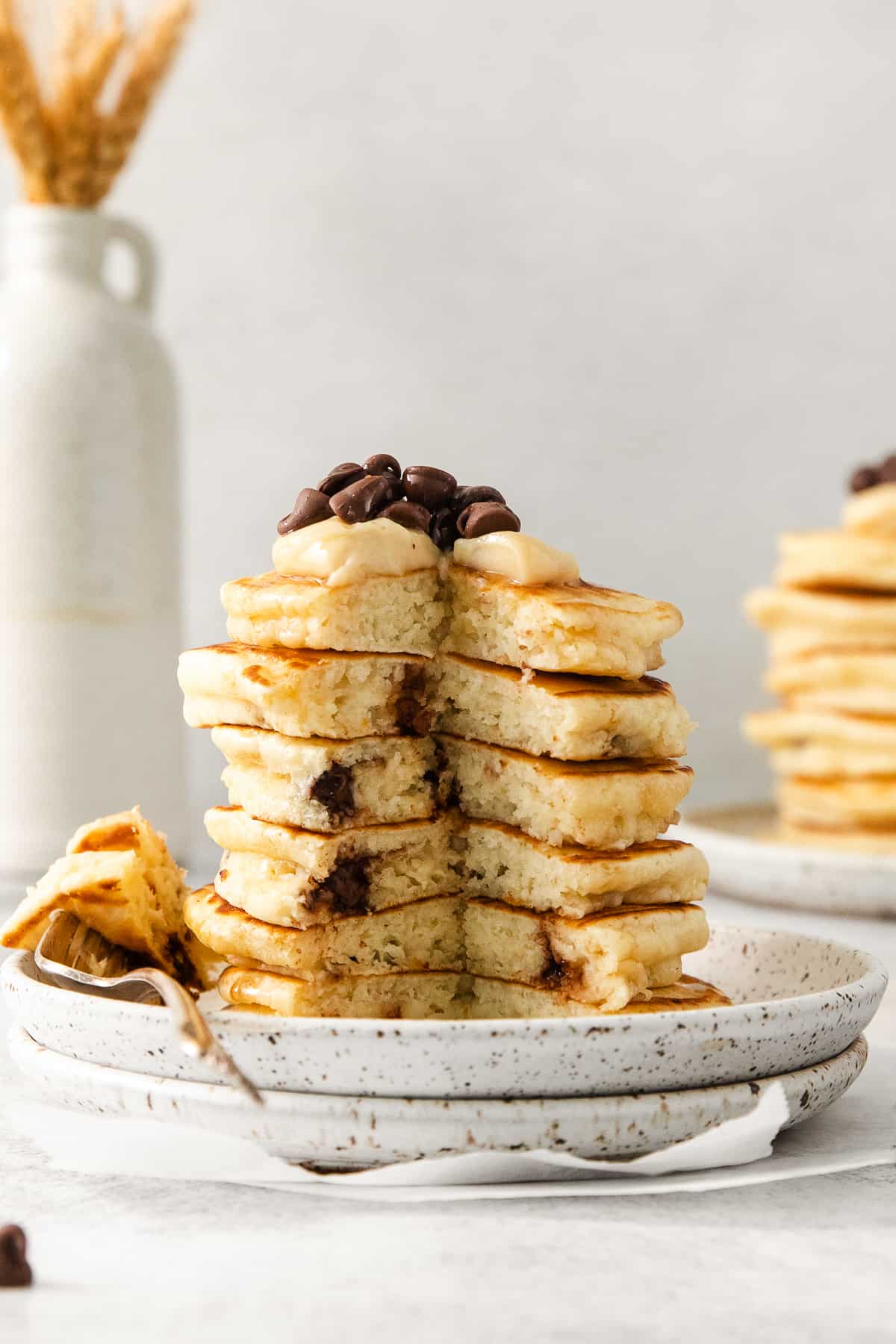 Cream cheese stuffed chocolate chip pancakes stacked on a plate.