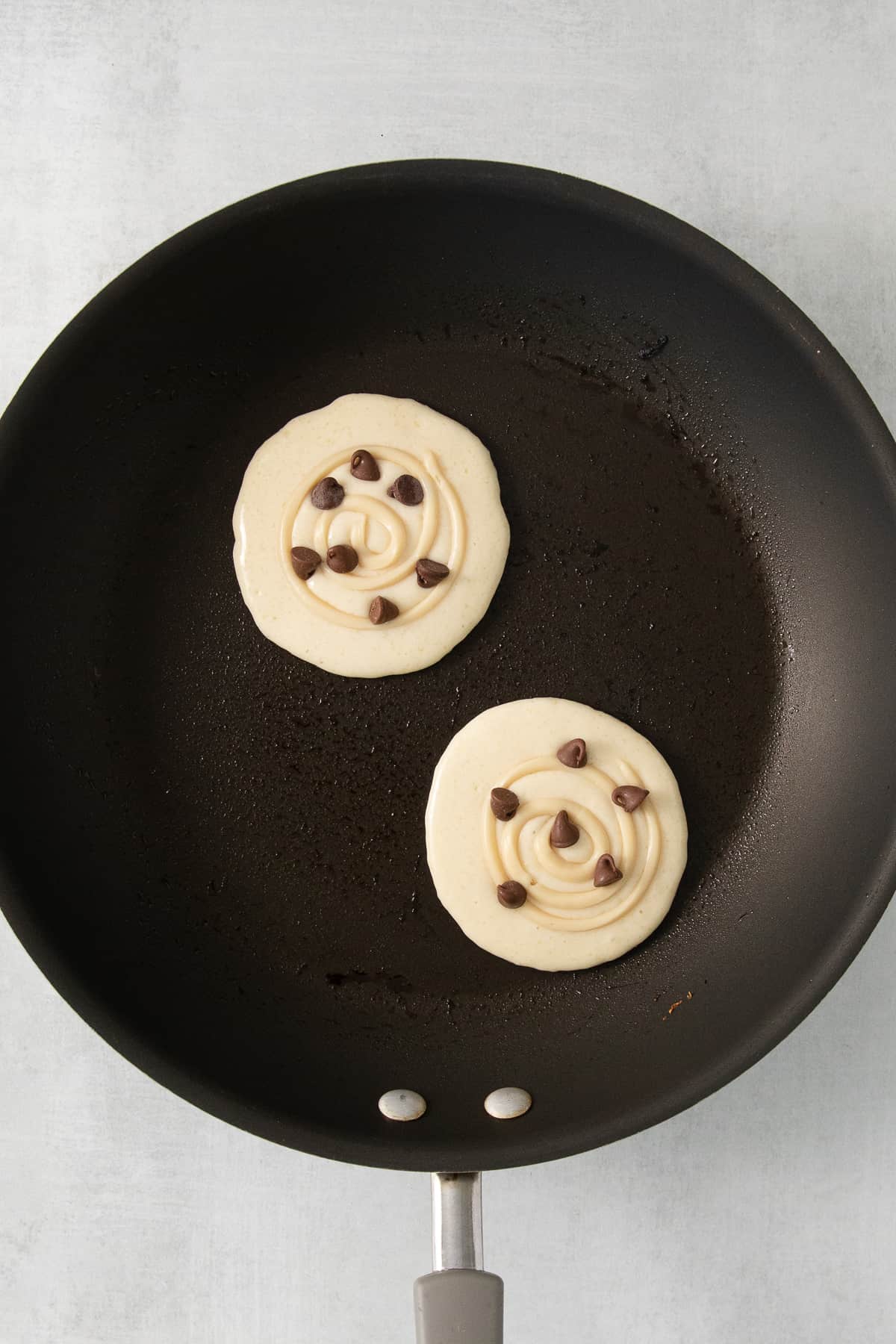 Cream cheese stuffed pancakes in a skillet.