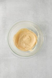 peanut butter in a glass bowl on a white background.