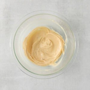 peanut butter in a glass bowl on a white background.