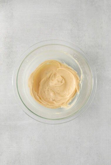 peanut butter in a glass bowl on a white background.