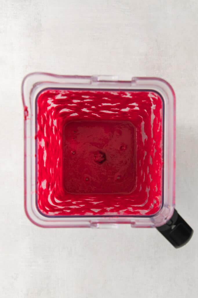 a blender with red liquid in it.