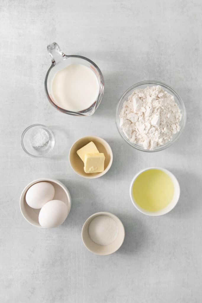 the ingredients for making a cake are shown on a gray background.