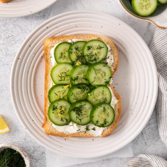 Cucumber and fresh dill on a piece of white bread.