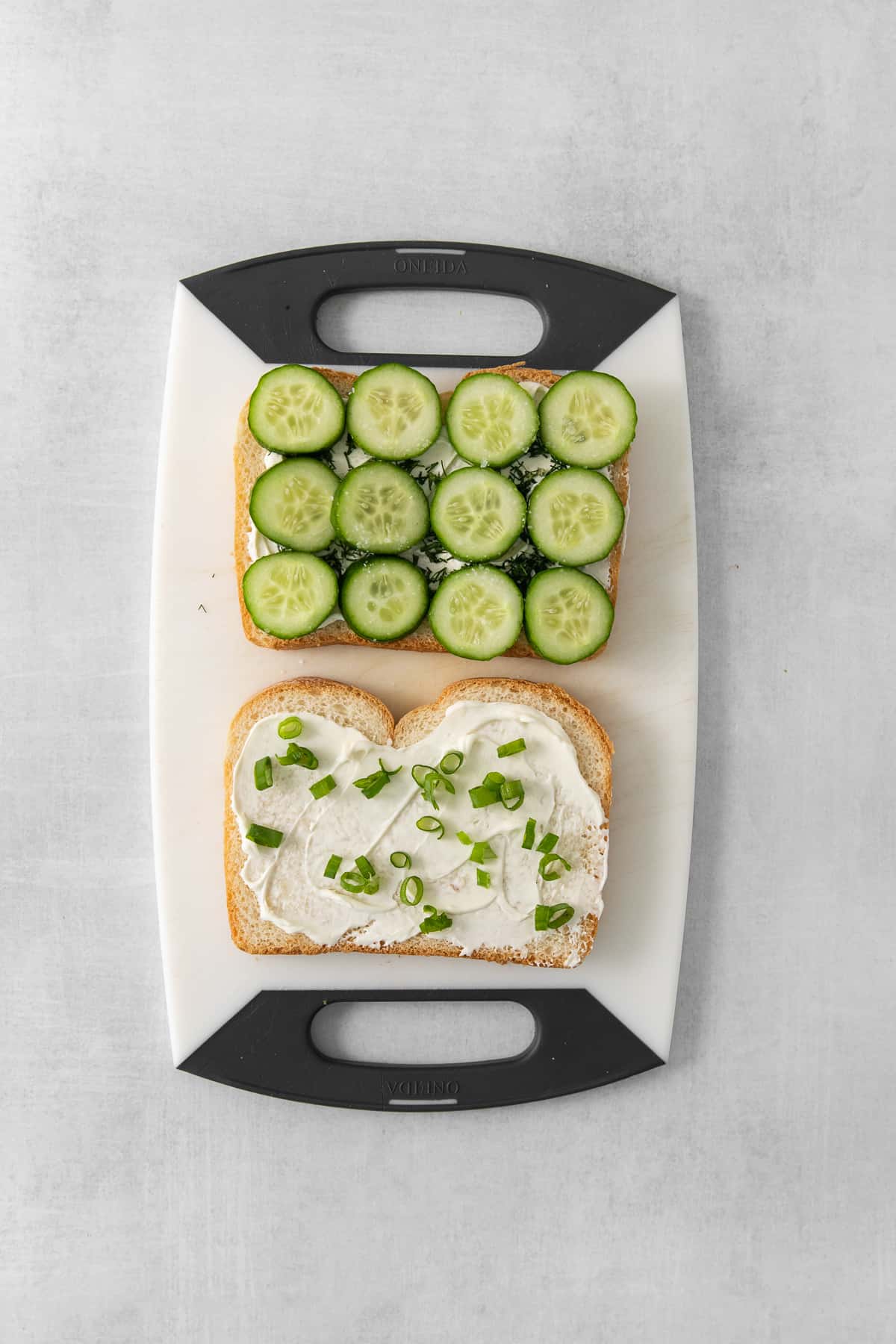 Cucumber, cream cheese, and fresh dill on white bread.