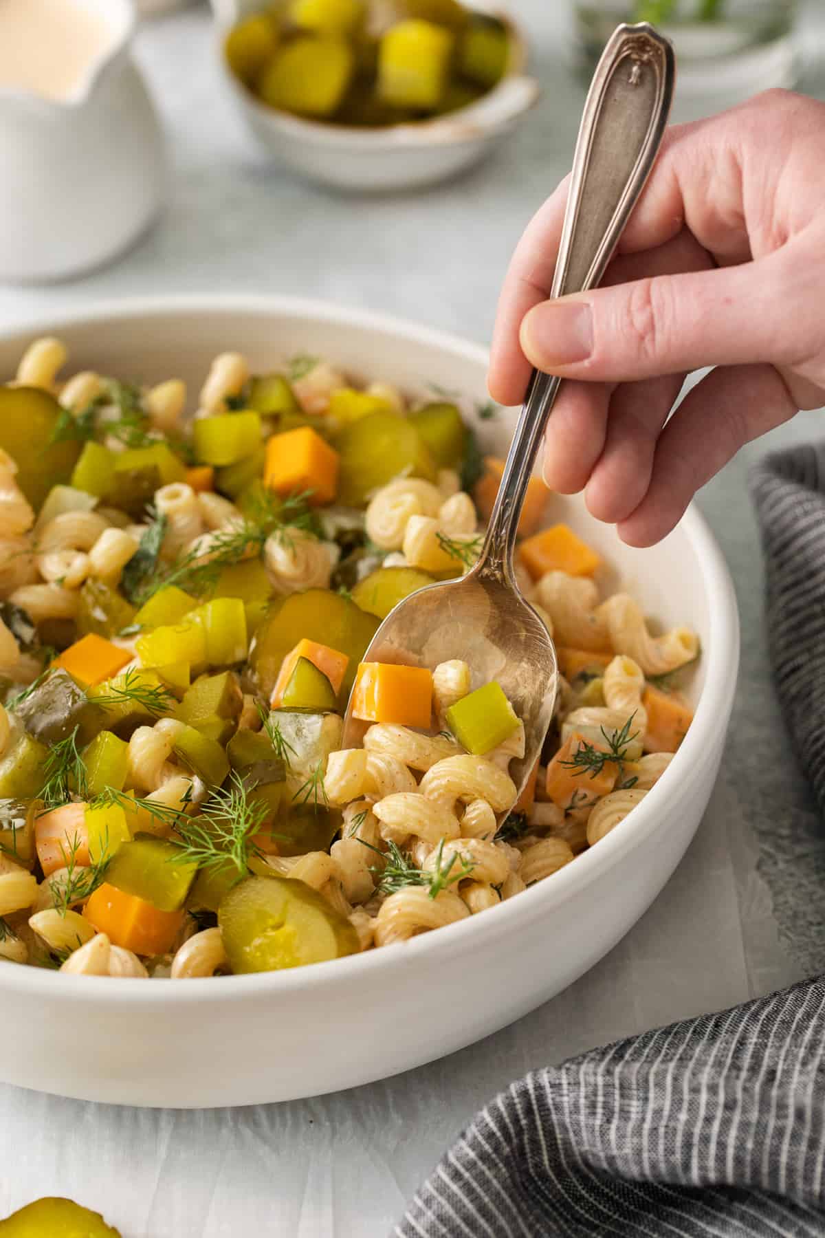 Dill pickle pasta salad on a spoon.