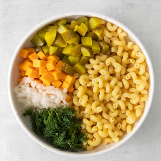 a bowl of macaroni and vegetables in a white bowl.