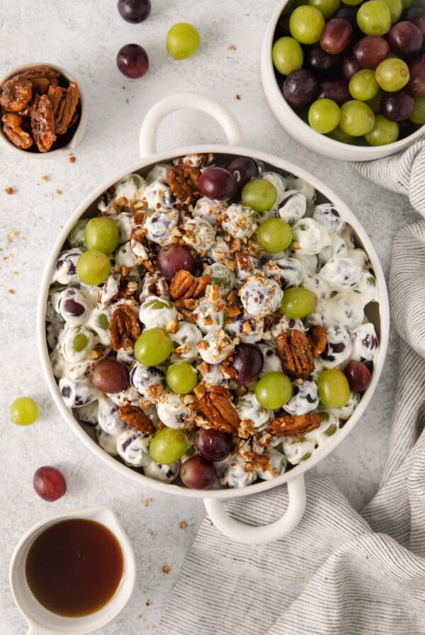 Grape salad in a bowl topped with candied pecans.