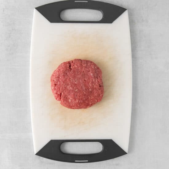a piece of ground beef on a cutting board.