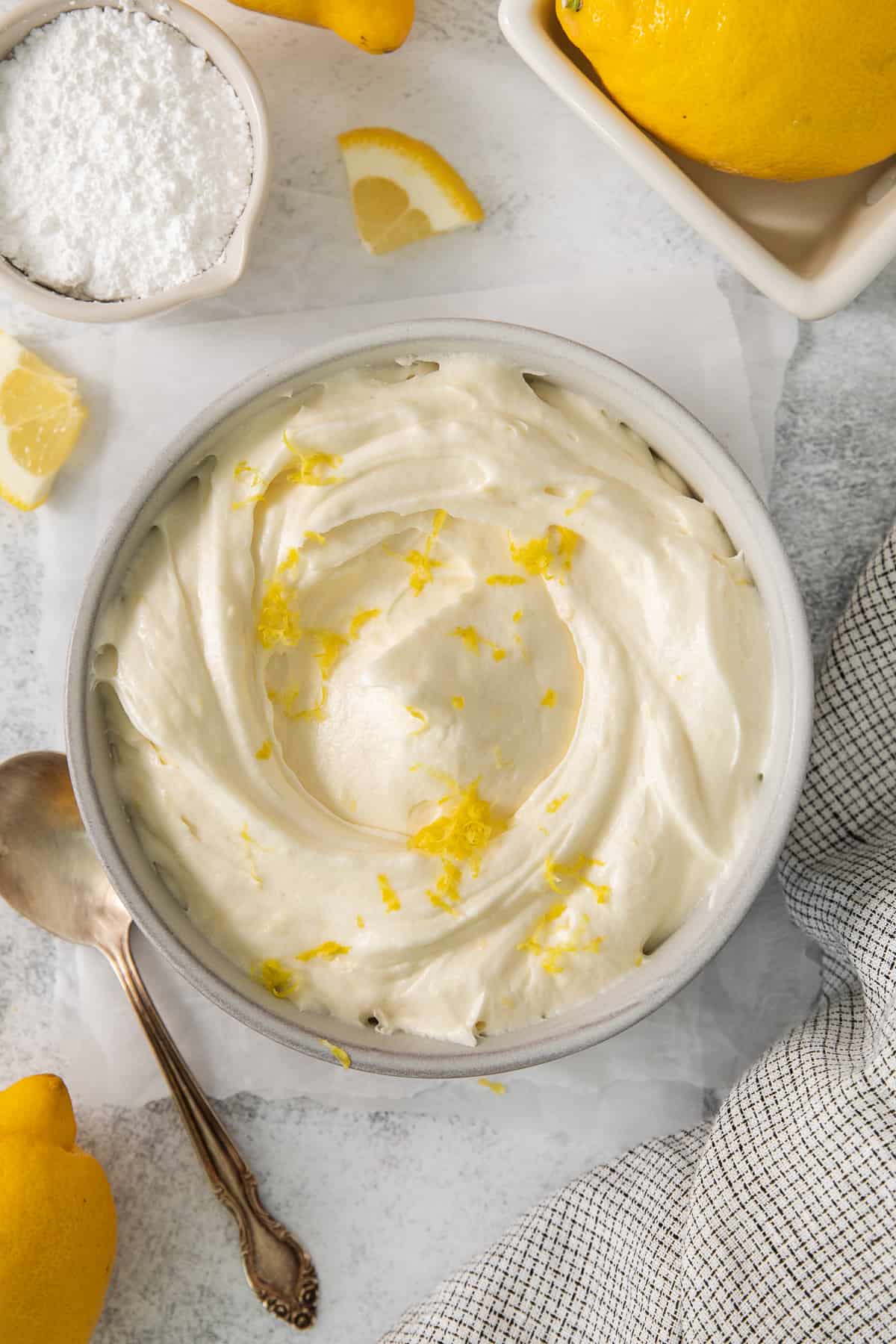 This lemon cream cheese frosting is the perfect compliment to your summertime desserts! The rich frosting gets balanced out with a delicious bright lemon flavor made from fresh lemons. Lemon cream cheese frosting in a bowl.