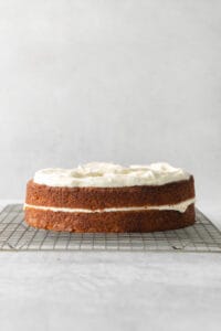 a carrot cake sitting on a cooling rack.