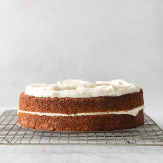 a carrot cake sitting on a cooling rack.