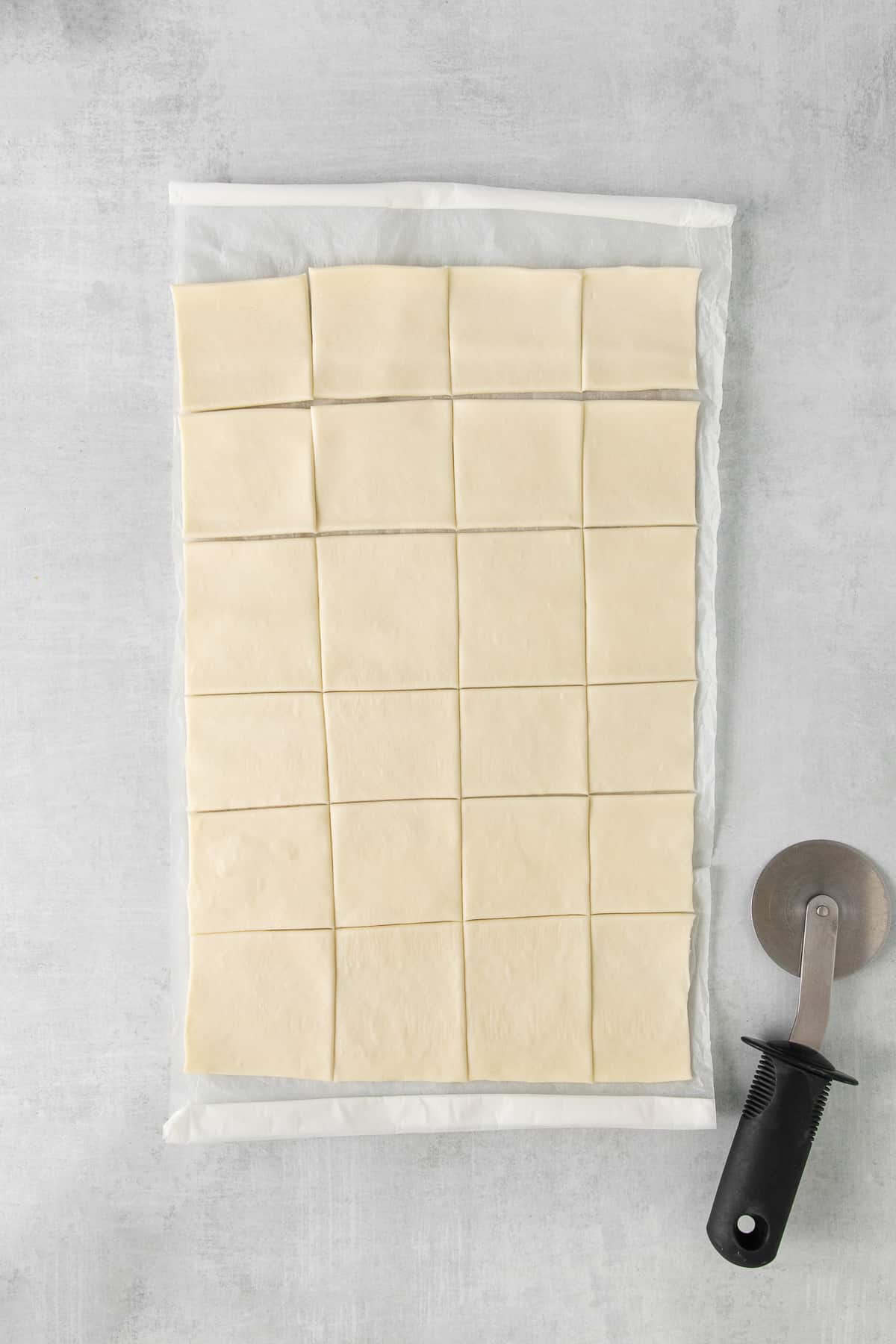 Sliced puff pastry on parchment paper.